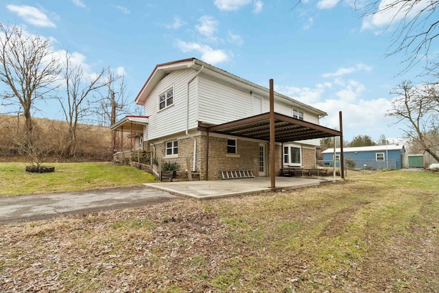 rear view of property with a lawn and a patio area