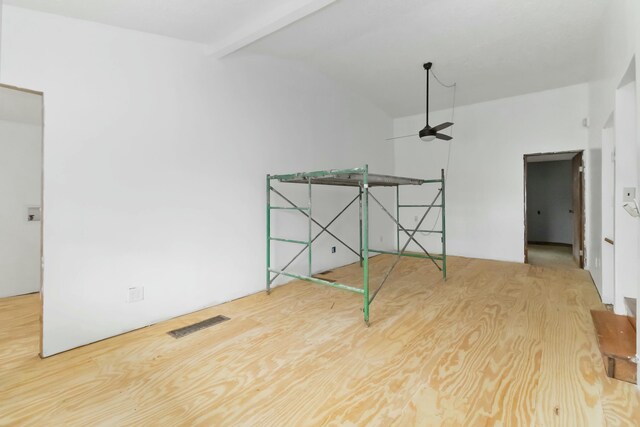 unfurnished room with ceiling fan and vaulted ceiling with beams