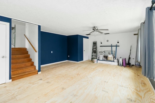 unfurnished living room with ceiling fan, wood-type flooring, and a textured ceiling