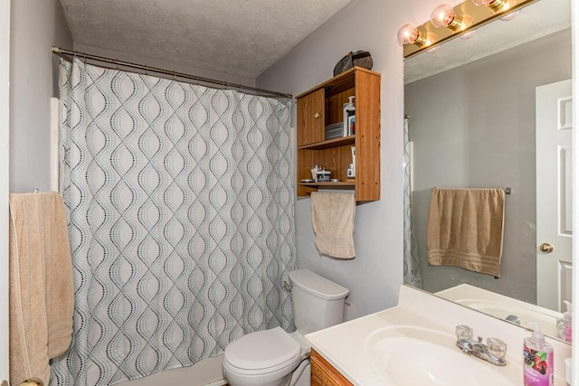 bathroom with vanity, toilet, and a textured ceiling