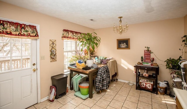 dining room with a notable chandelier, a textured ceiling, and light tile patterned flooring