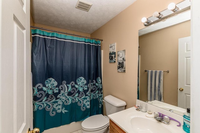 bathroom with vanity, curtained shower, toilet, and a textured ceiling