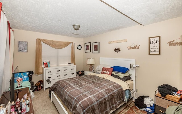 bedroom with light carpet and a textured ceiling