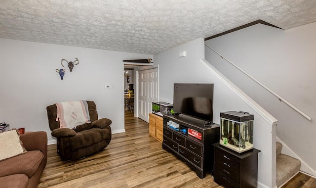 living room with light hardwood / wood-style floors and a textured ceiling