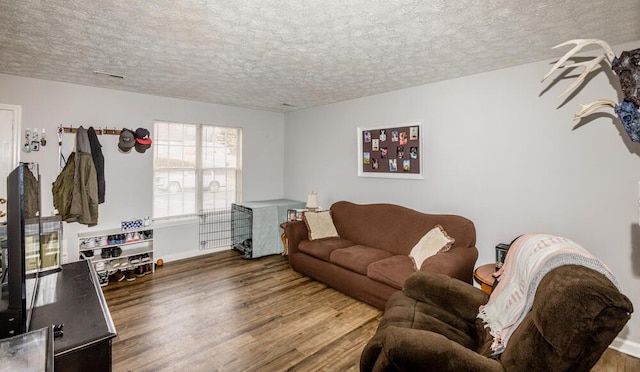 living room featuring dark hardwood / wood-style floors and a textured ceiling