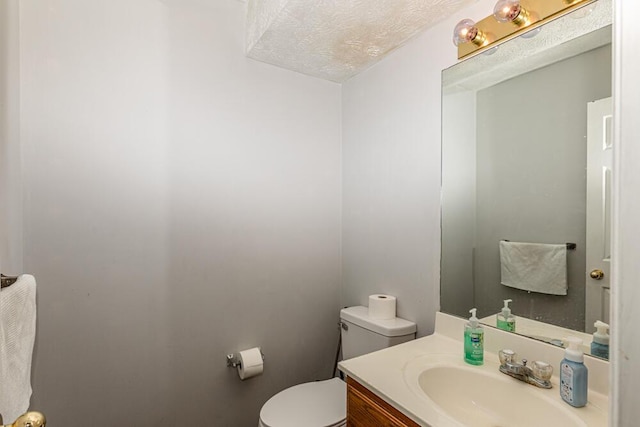 bathroom with vanity, a textured ceiling, and toilet