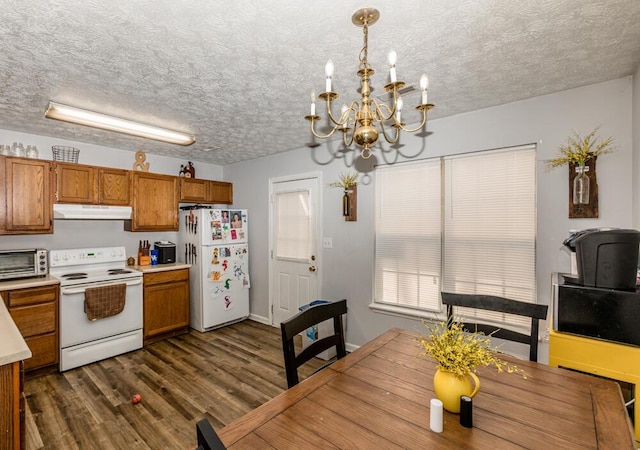 kitchen with white appliances, dark wood-type flooring, a textured ceiling, decorative light fixtures, and a chandelier