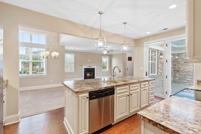 kitchen with decorative light fixtures, sink, a kitchen island with sink, stainless steel dishwasher, and a healthy amount of sunlight