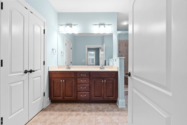 bathroom featuring vanity, tile patterned floors, and walk in shower