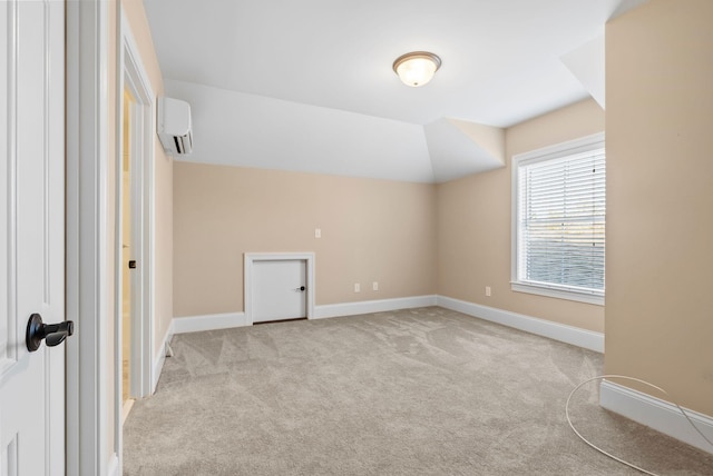 spare room with light colored carpet, a wall mounted air conditioner, and vaulted ceiling