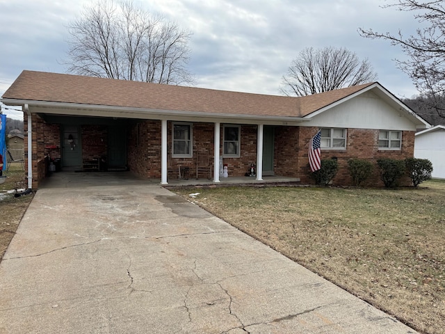 ranch-style house with a carport, covered porch, and a front lawn