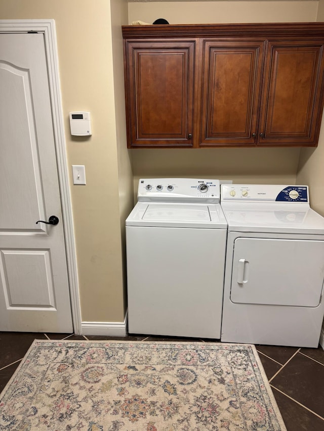 laundry area with cabinets, independent washer and dryer, and dark tile patterned flooring