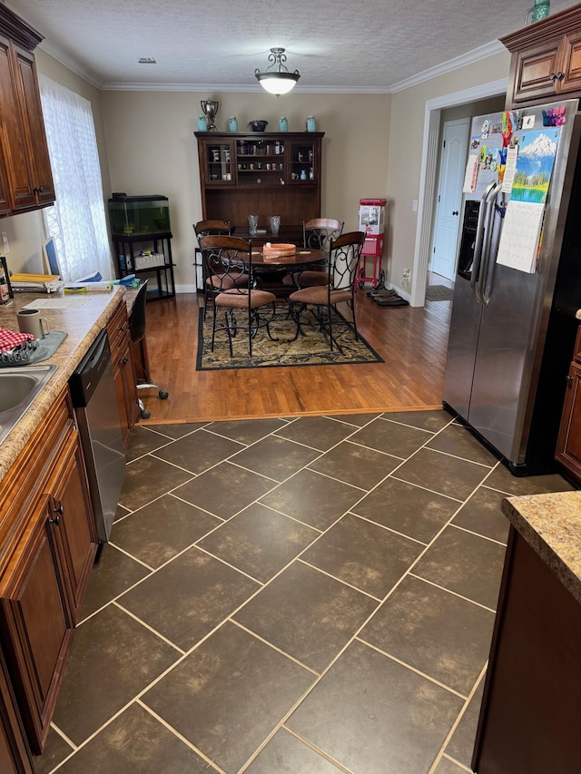 kitchen with crown molding, dark wood-type flooring, a textured ceiling, and appliances with stainless steel finishes