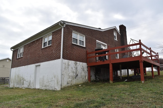 back of house with a wooden deck and a lawn