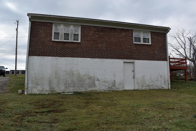 view of side of home with a yard