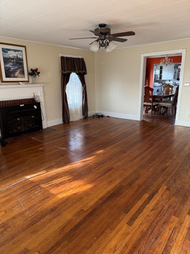 unfurnished living room featuring dark wood-type flooring and ceiling fan with notable chandelier