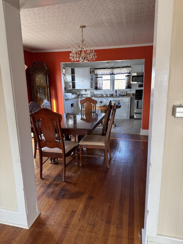 dining room featuring hardwood / wood-style floors, ornamental molding, and a chandelier