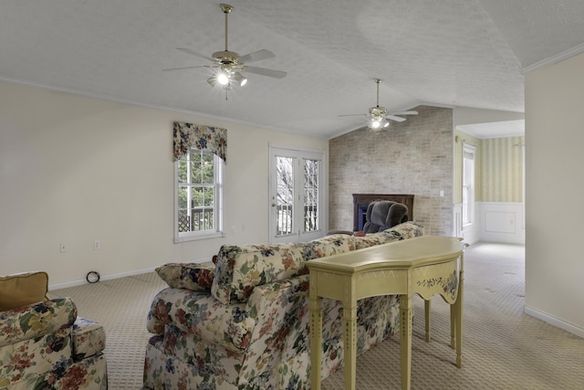 living room with lofted ceiling, a textured ceiling, ornamental molding, light colored carpet, and a fireplace