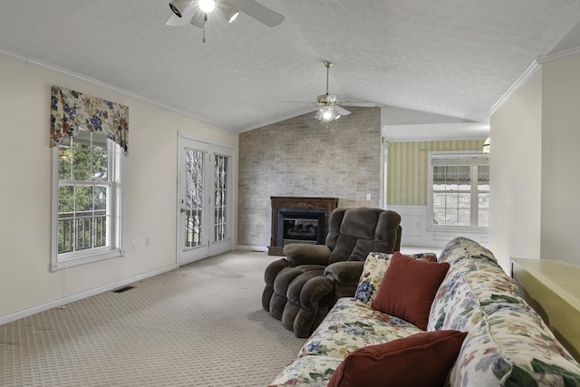 carpeted living room featuring ornamental molding, plenty of natural light, a fireplace, and a textured ceiling