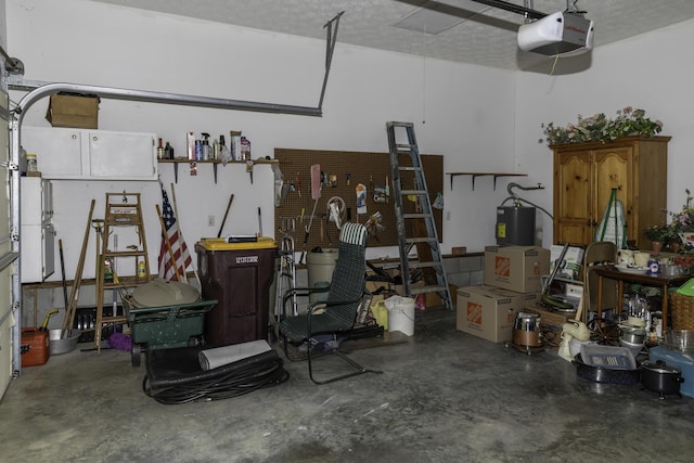 garage with a garage door opener, a workshop area, and water heater