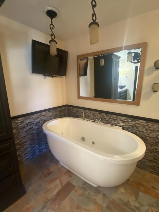 bathroom featuring tile walls and a washtub