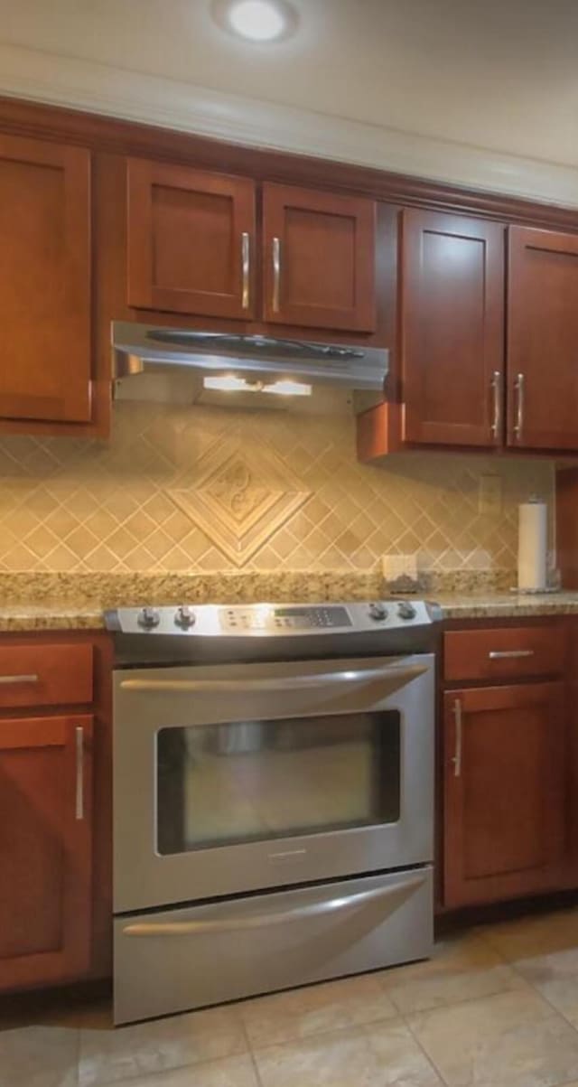 kitchen featuring tasteful backsplash, stainless steel electric range oven, and light stone countertops