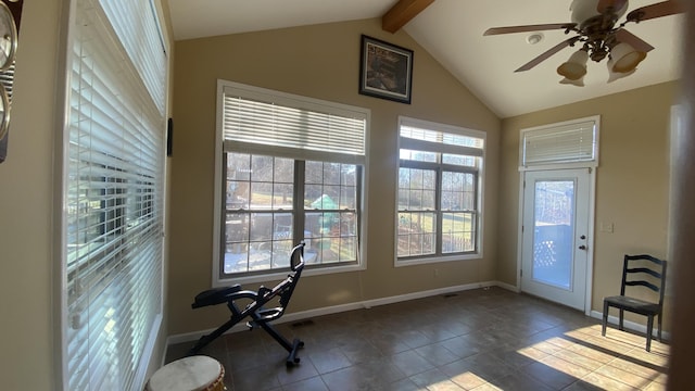 interior space with ceiling fan, lofted ceiling, a healthy amount of sunlight, and dark tile patterned flooring