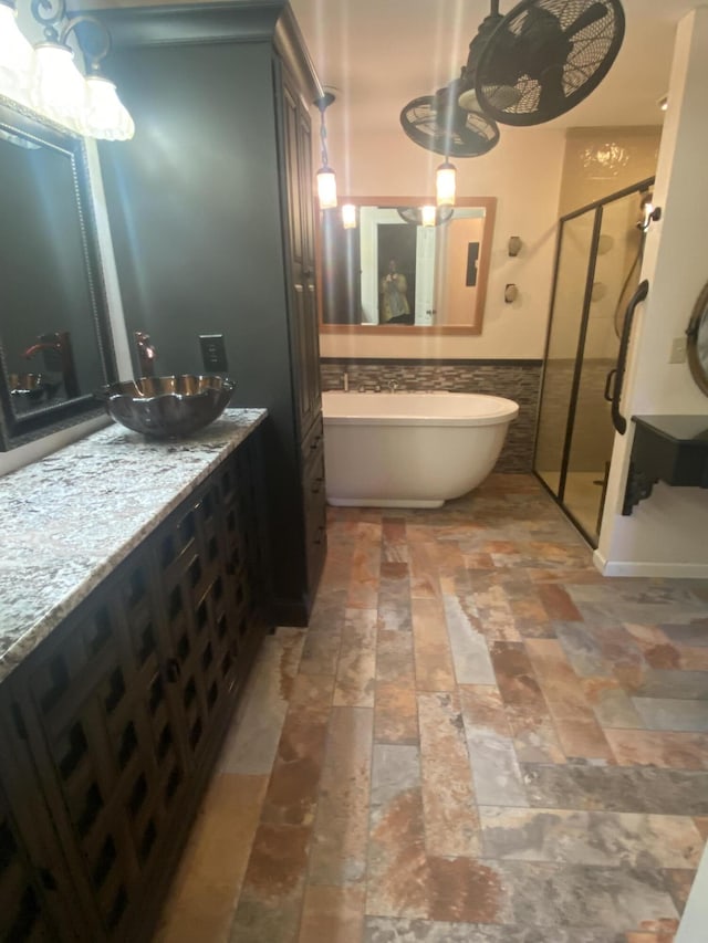 bathroom with plus walk in shower, tile walls, and vanity