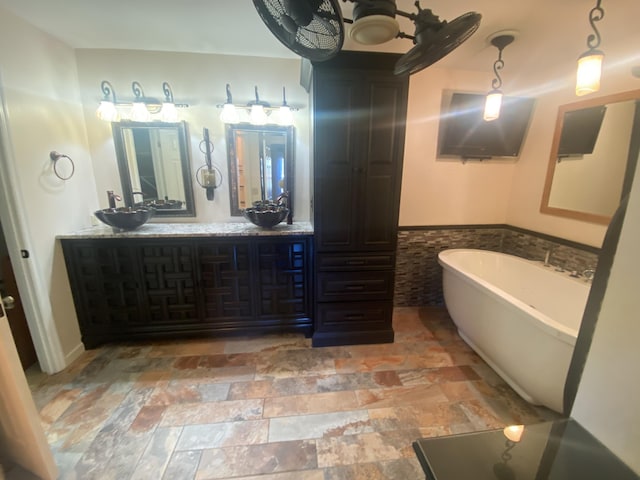 bathroom featuring vanity, tile walls, and a washtub