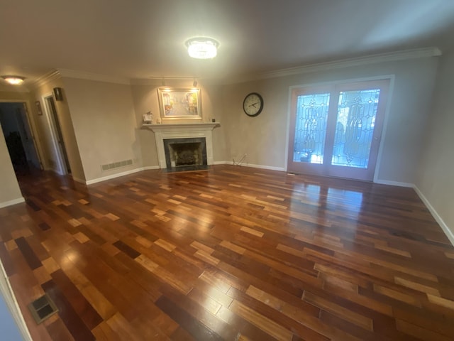 unfurnished living room featuring dark wood-type flooring and ornamental molding