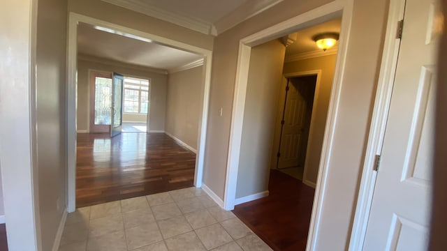 corridor with light tile patterned floors and ornamental molding