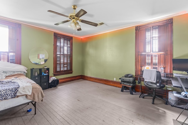 bedroom featuring ornamental molding, light hardwood / wood-style floors, and ceiling fan