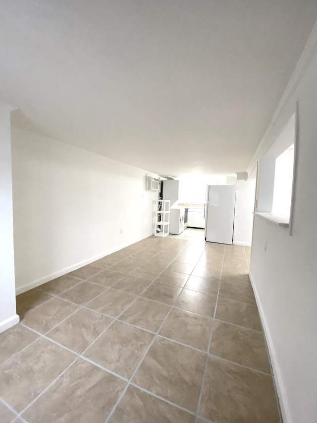 empty room with a wall mounted AC and light tile patterned flooring