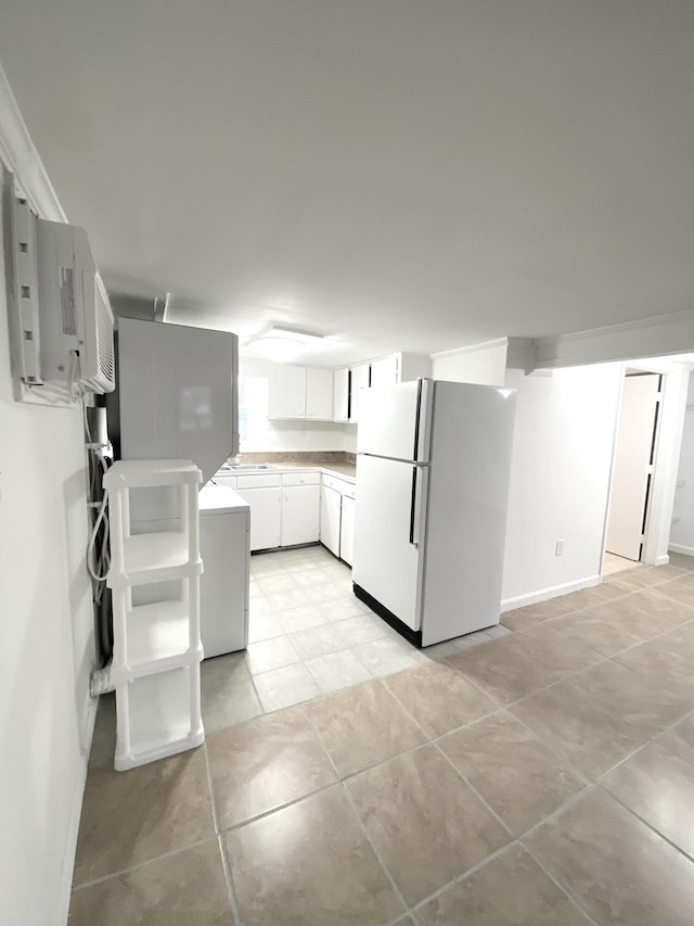 kitchen featuring white fridge, sink, light tile patterned floors, and white cabinets