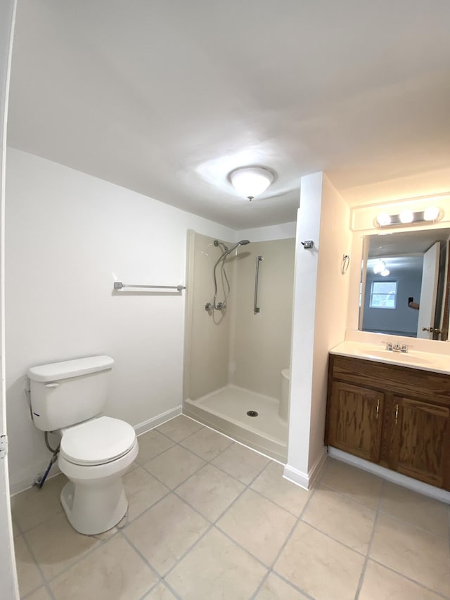 bathroom with vanity, tile patterned flooring, toilet, and a shower