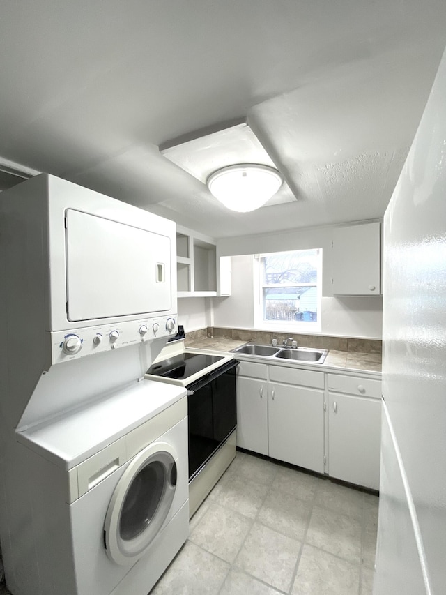 kitchen with white cabinetry, sink, range with electric cooktop, and stacked washer and clothes dryer