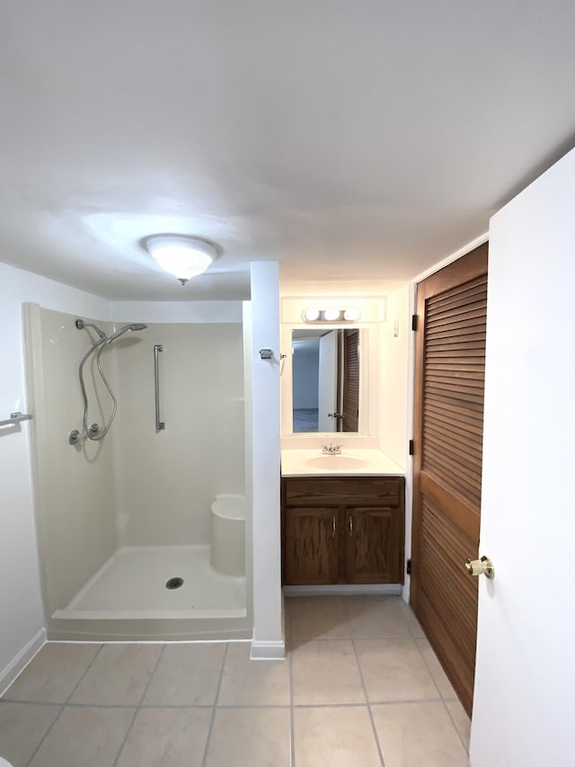 bathroom with a shower, tile patterned floors, and vanity