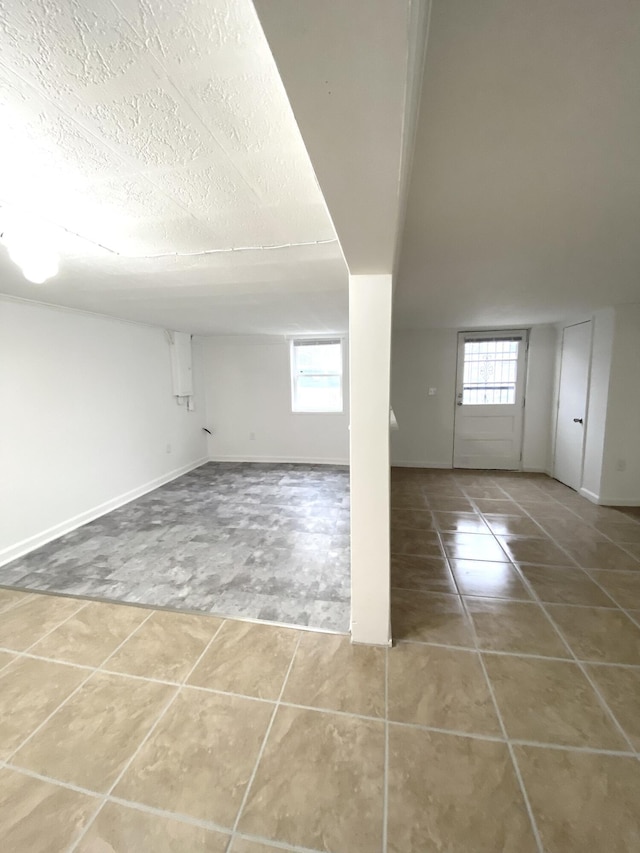 interior space with tile patterned floors, plenty of natural light, and a textured ceiling