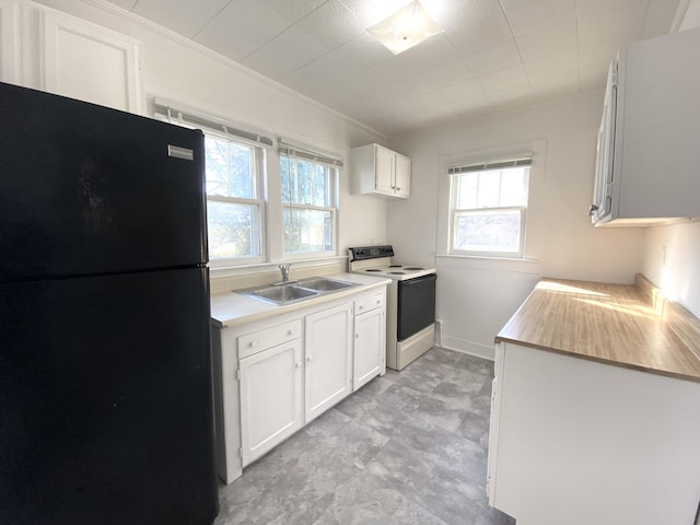 kitchen featuring black fridge, sink, white electric range oven, and white cabinets