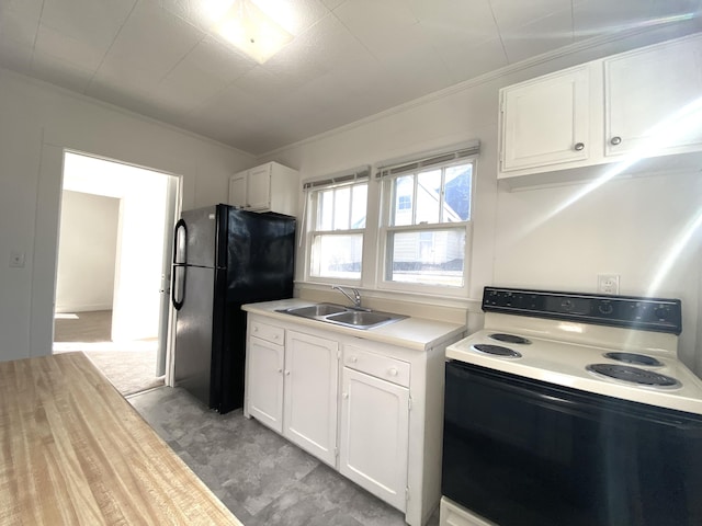 kitchen with range with electric cooktop, black refrigerator, white cabinetry, sink, and ornamental molding