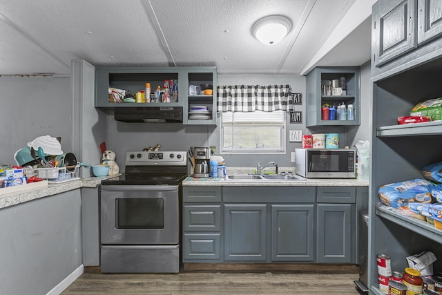 kitchen with sink, dark wood-type flooring, gray cabinets, stainless steel appliances, and a textured ceiling