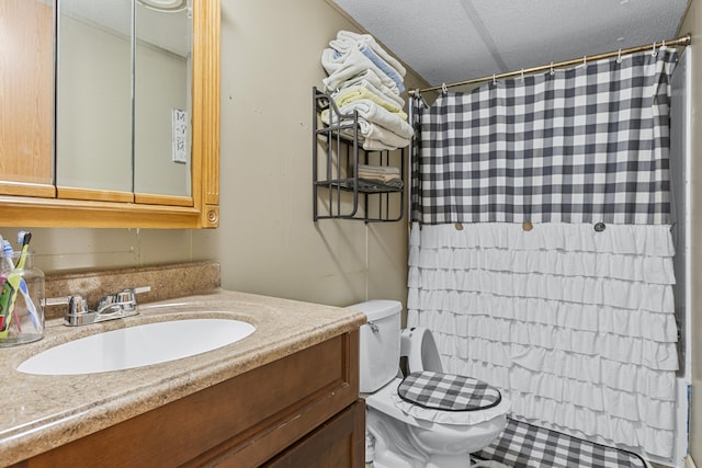 bathroom featuring vanity, a textured ceiling, toilet, and walk in shower