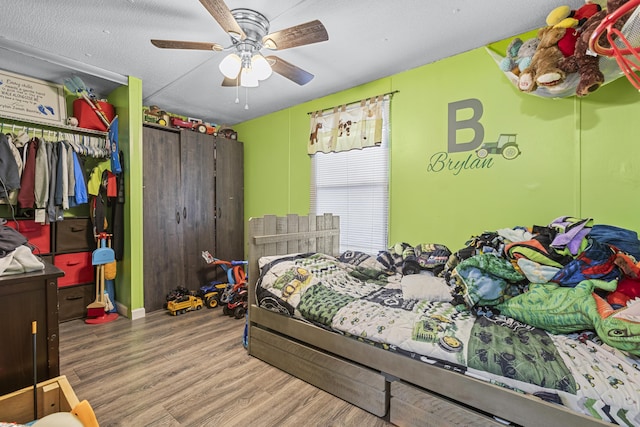 bedroom featuring wood-type flooring, ceiling fan, and a closet