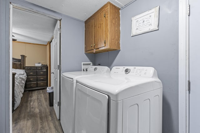 washroom with cabinets, separate washer and dryer, dark hardwood / wood-style floors, and a textured ceiling