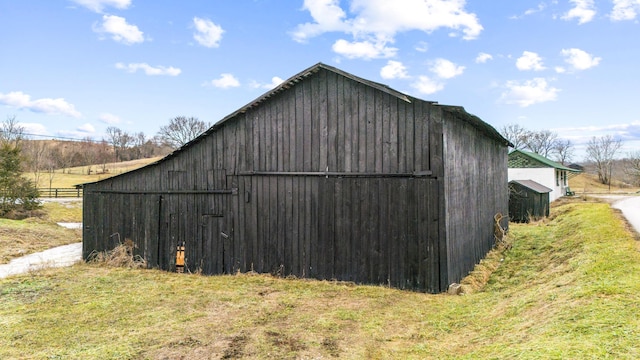 view of outbuilding featuring a lawn and a rural view