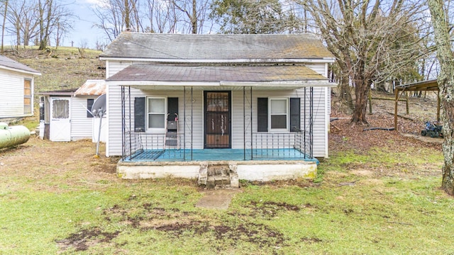 bungalow-style home featuring covered porch and a front yard