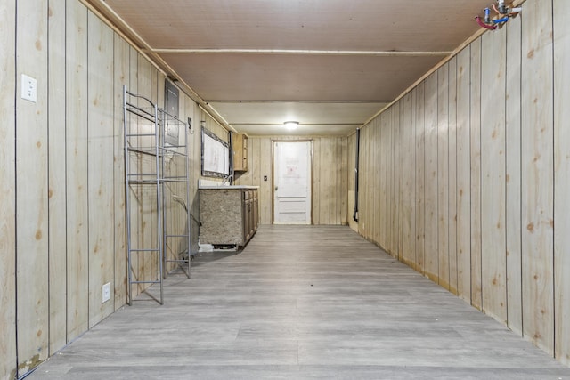 basement with wooden walls, wooden ceiling, and light wood-type flooring