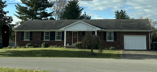 single story home featuring an attached garage, a front lawn, brick siding, and concrete driveway