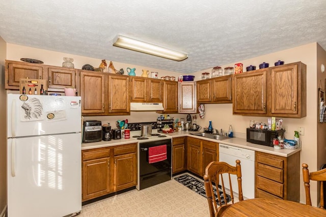 kitchen with sink, white appliances, and a textured ceiling