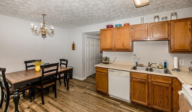 kitchen with pendant lighting, sink, range, white dishwasher, and dark wood-type flooring